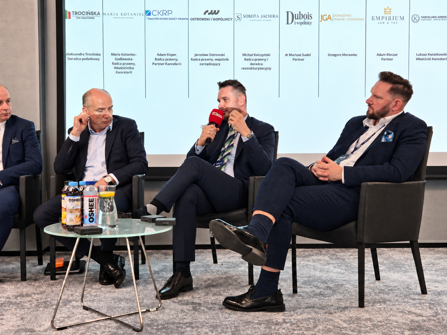 Adam Klęczar z mikrofonem podczas panelu „Prawo i podatki w biznesie przyszłości” na MFG 2026.